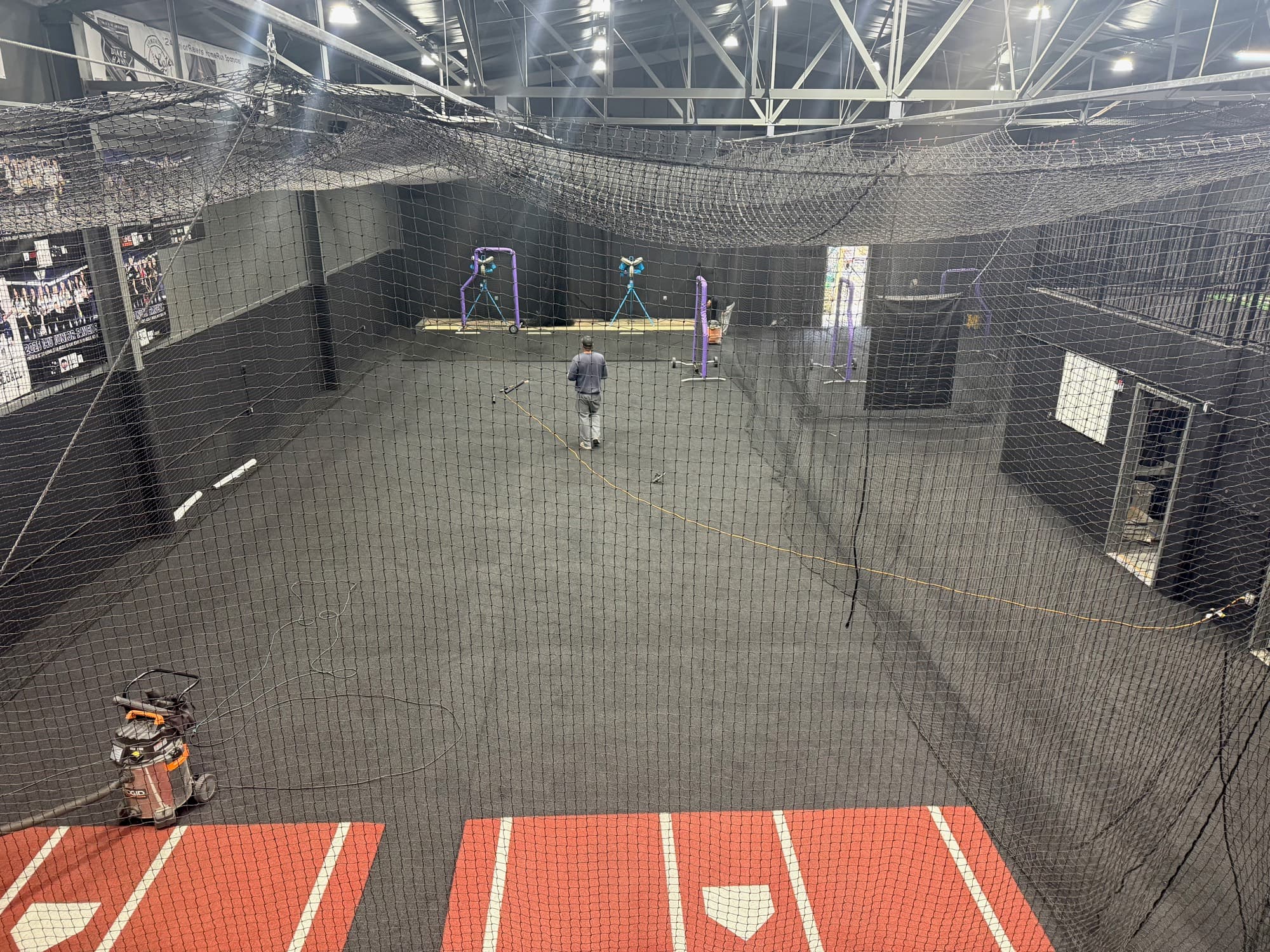 Inside the Junior Ravens Clubhouse — batting cages, pitching machines, and the black turf floor under the lights