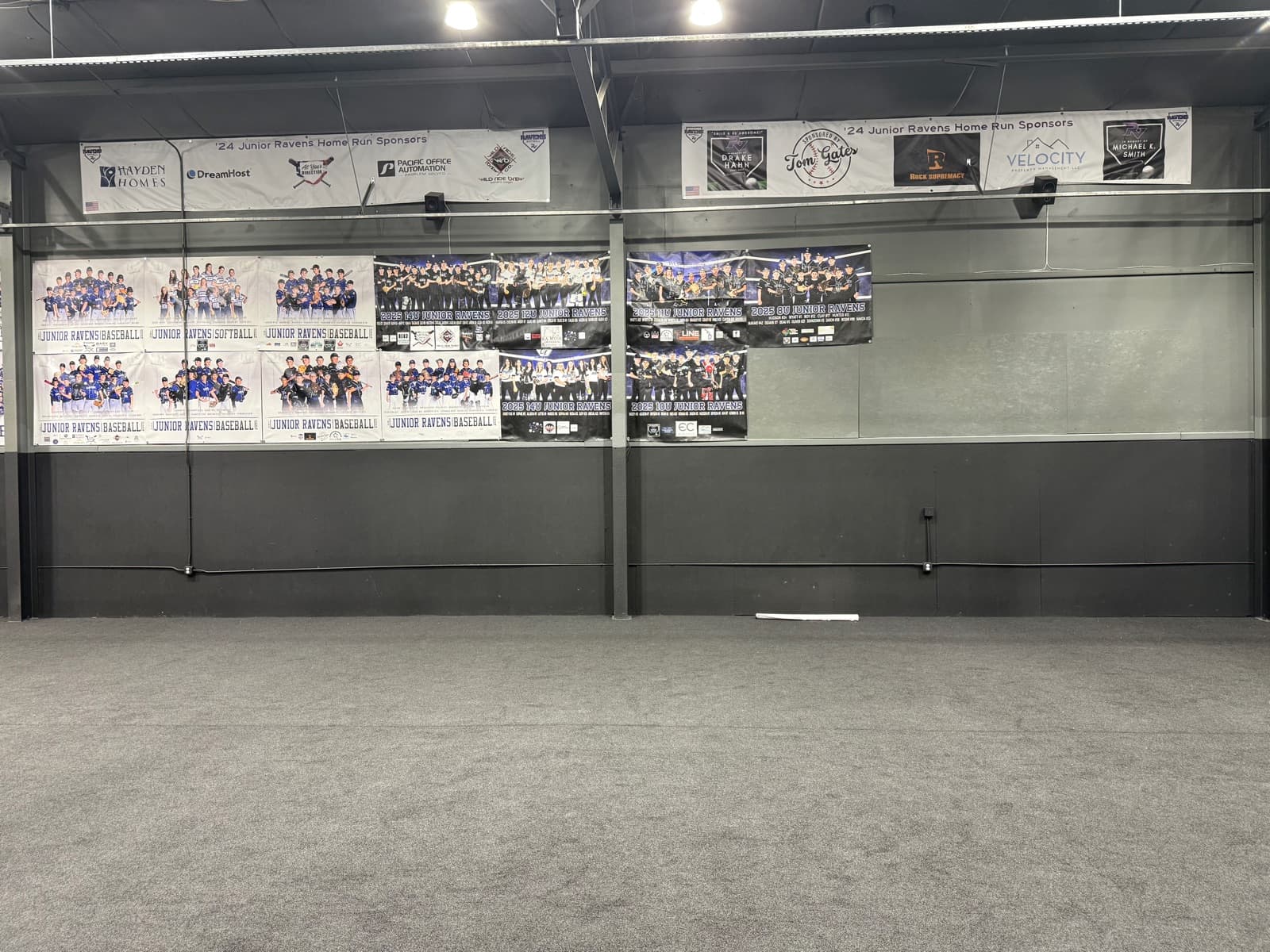 Team posters and sponsor banners lining the clubhouse wall